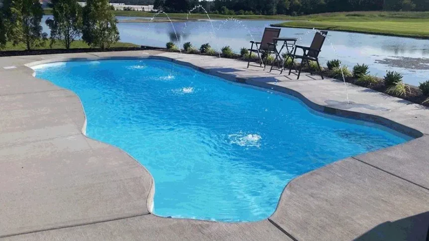 Columbia large fiberglass pool model with custom water features and is waterfront to a bay.