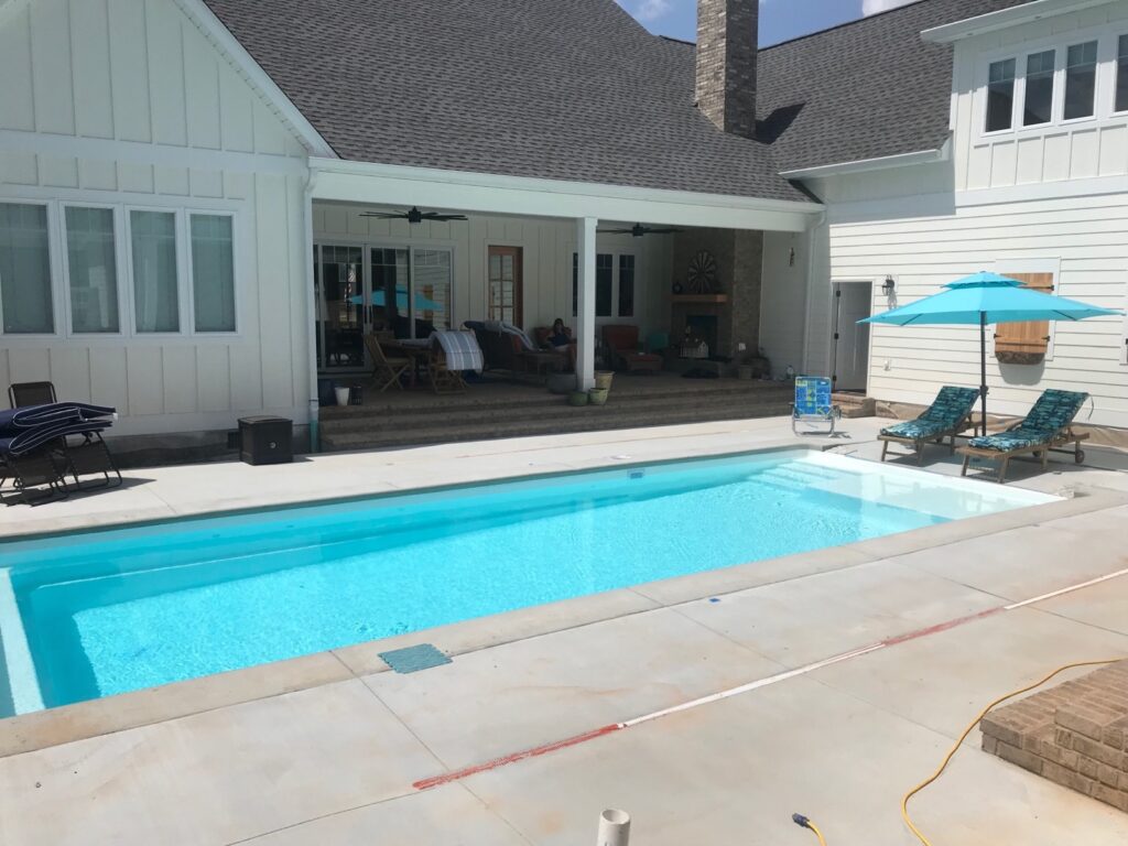Birmingham rectangular white fiberglass inground pool and backyard patio.