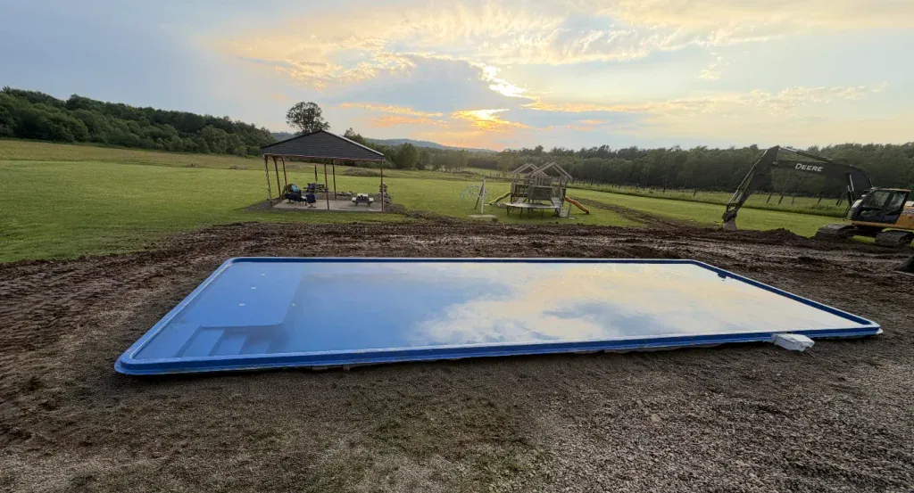 large fiberglass pool with tanning ledge new installation